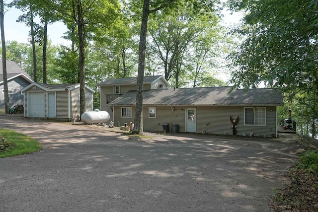 view of front of home with a garage and an outbuilding