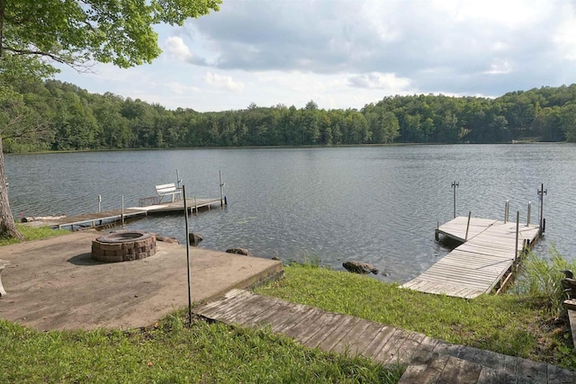 dock area with a water view and a fire pit