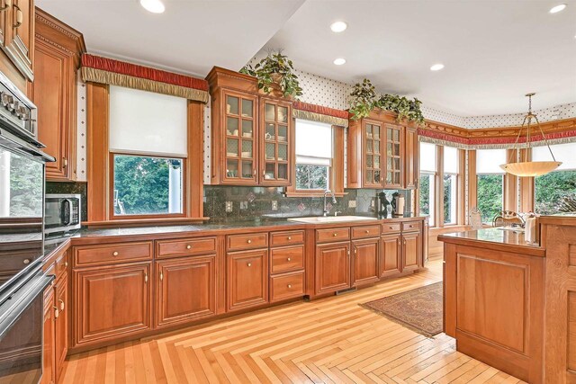 kitchen with sink, hanging light fixtures, and light parquet flooring