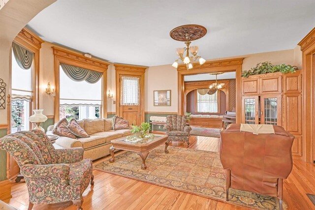 living room with a notable chandelier and light hardwood / wood-style flooring