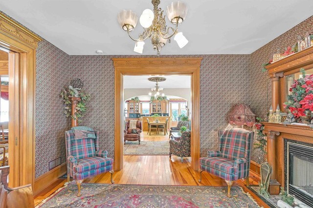 sitting room with hardwood / wood-style floors and a notable chandelier