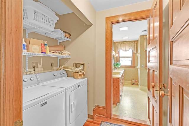 washroom with separate washer and dryer and sink