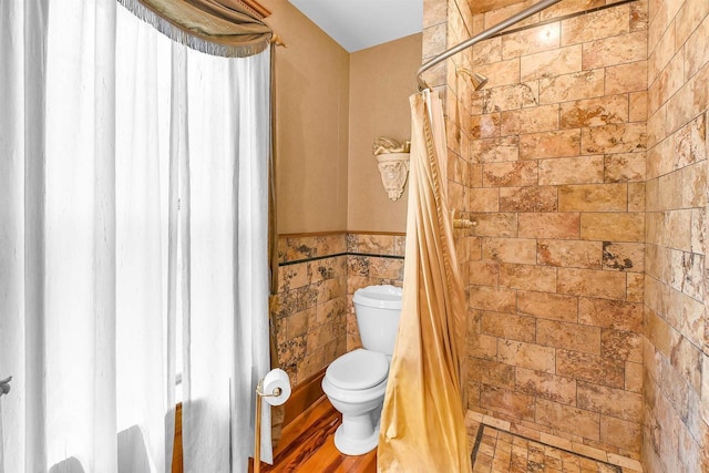 bathroom featuring toilet, tile walls, wood-type flooring, and curtained shower