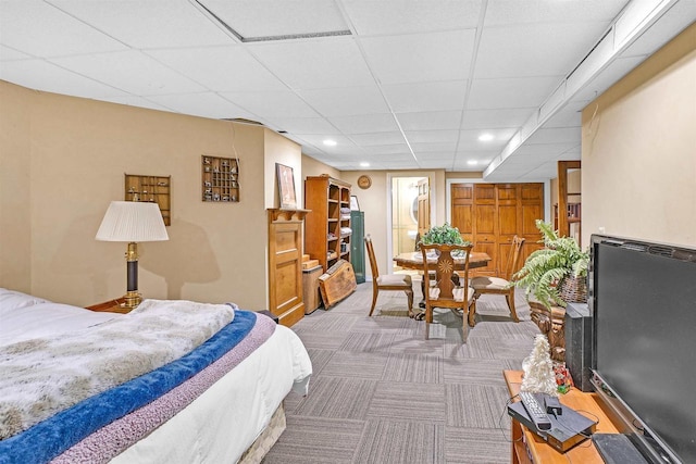 bedroom featuring carpet and a drop ceiling