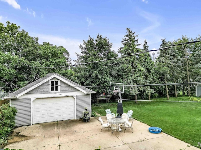 view of patio with a garage and an outbuilding