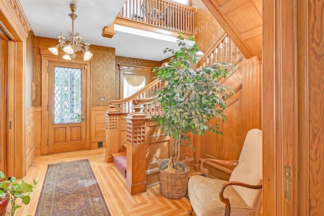 foyer entrance with an inviting chandelier and wooden walls