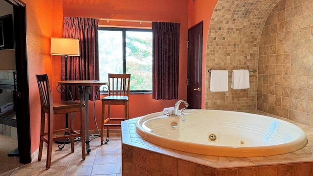 bathroom with vaulted ceiling, tile patterned floors, and a relaxing tiled tub