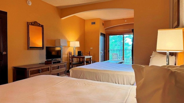 bedroom featuring access to exterior and a textured ceiling