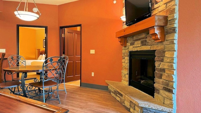 dining room with a fireplace, a textured ceiling, and light hardwood / wood-style flooring