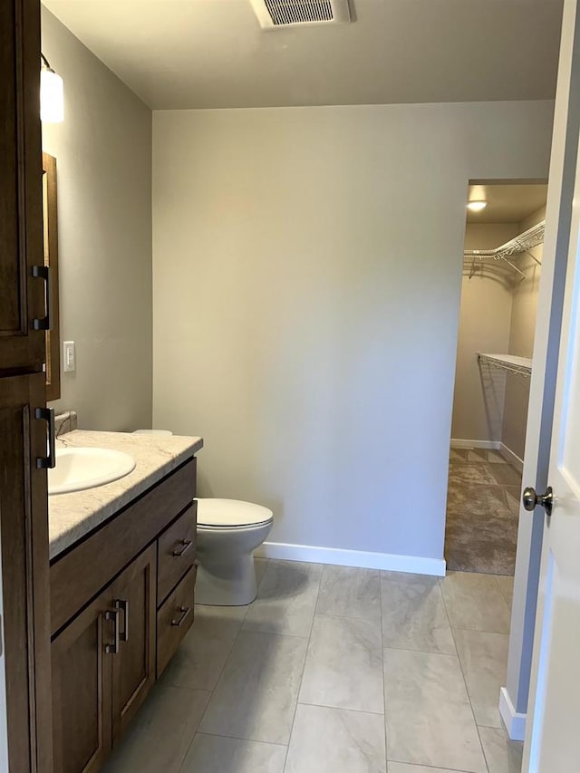 bathroom featuring toilet, tile patterned flooring, and vanity