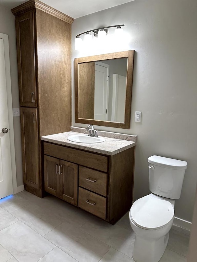 bathroom with toilet, tile patterned floors, and vanity