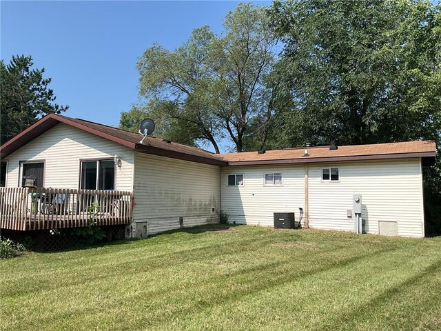 back of property with central air condition unit, a lawn, and a wooden deck