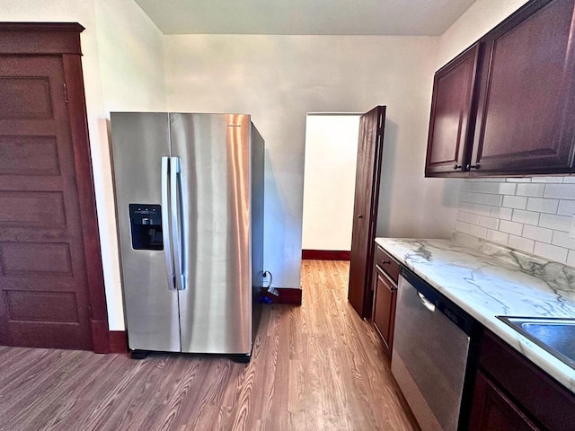 kitchen featuring decorative backsplash, appliances with stainless steel finishes, dark hardwood / wood-style flooring, and dark brown cabinets