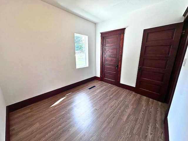 unfurnished bedroom with dark hardwood / wood-style floors