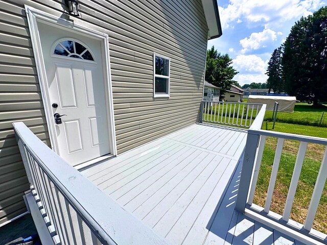 wooden terrace featuring a lawn