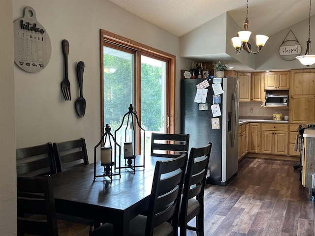 dining area featuring lofted ceiling, dark hardwood / wood-style floors, and a notable chandelier