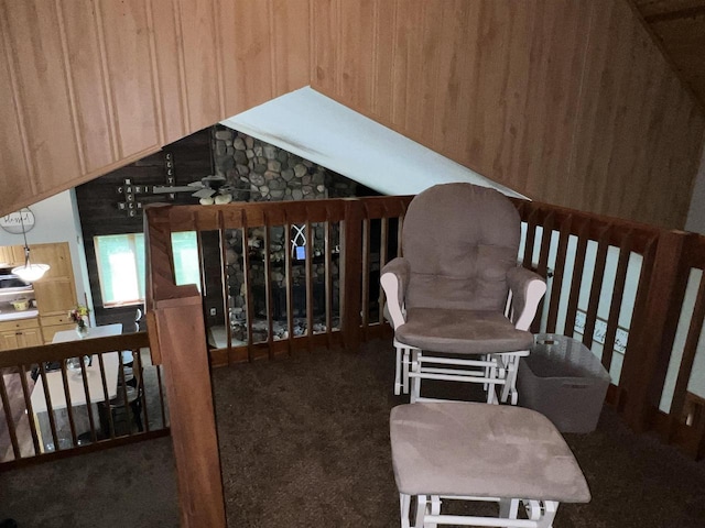 living area featuring dark carpet and wood walls