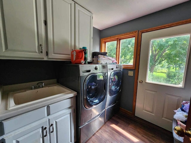 washroom featuring cabinets, hardwood / wood-style flooring, sink, and washing machine and clothes dryer