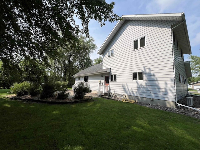 back of house featuring a yard and central air condition unit