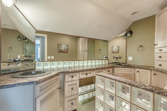 bathroom with tile patterned flooring, vanity, and vaulted ceiling