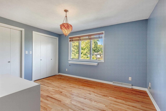 unfurnished bedroom with two closets and light hardwood / wood-style floors