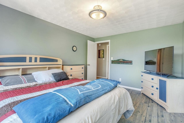 bedroom with a textured ceiling and hardwood / wood-style flooring