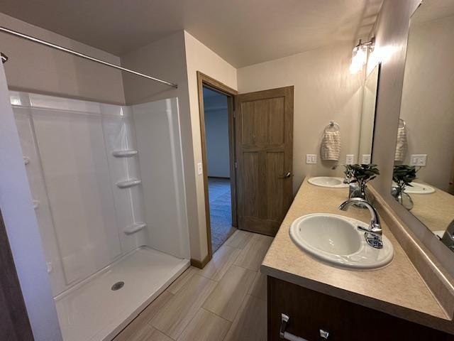 bathroom featuring walk in shower and vanity