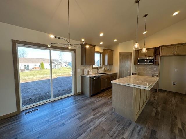 kitchen featuring a kitchen island, dishwasher, tasteful backsplash, and hanging light fixtures