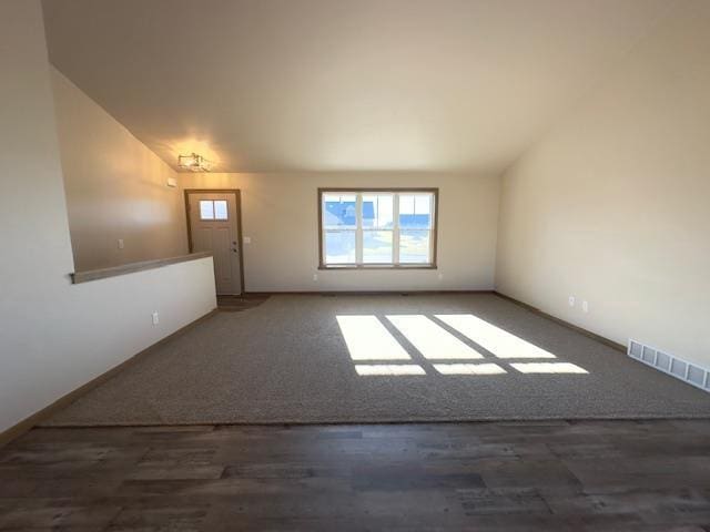 empty room featuring lofted ceiling and dark hardwood / wood-style floors