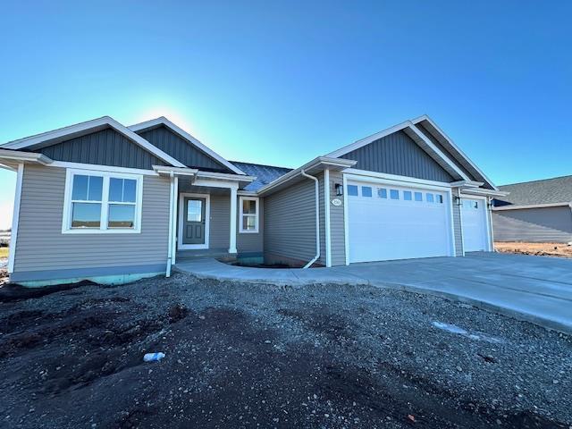 view of front of property with board and batten siding, driveway, and an attached garage