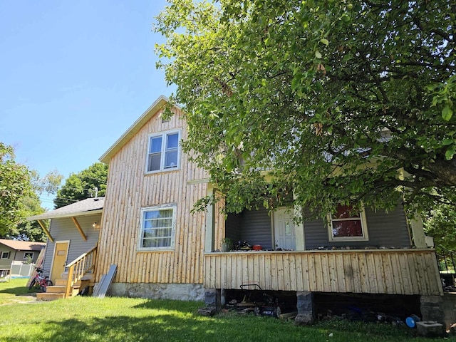 rear view of property featuring a lawn