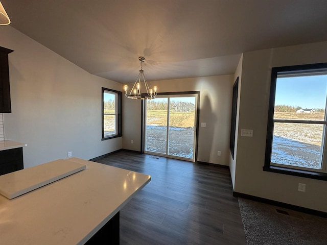 unfurnished dining area featuring dark hardwood / wood-style flooring and a notable chandelier