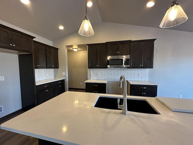 kitchen featuring lofted ceiling, backsplash, sink, and pendant lighting