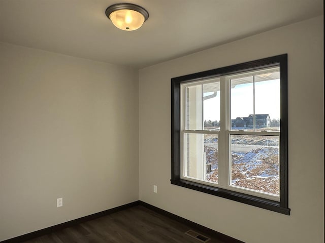 empty room with dark hardwood / wood-style flooring