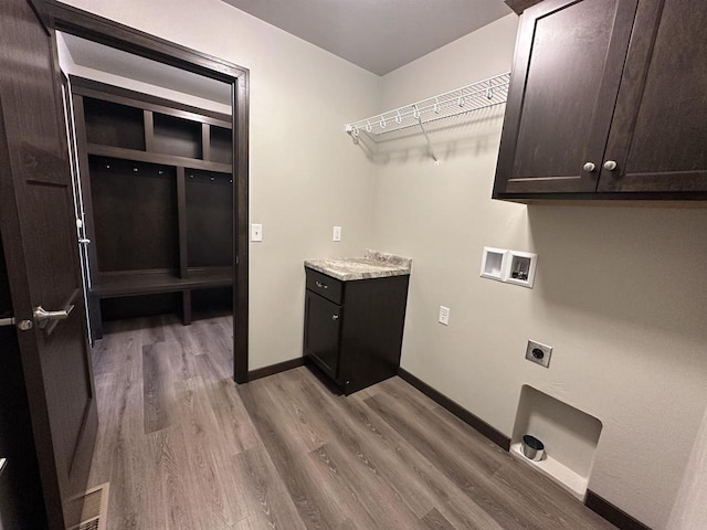 clothes washing area with washer hookup, cabinets, hookup for an electric dryer, and light hardwood / wood-style floors