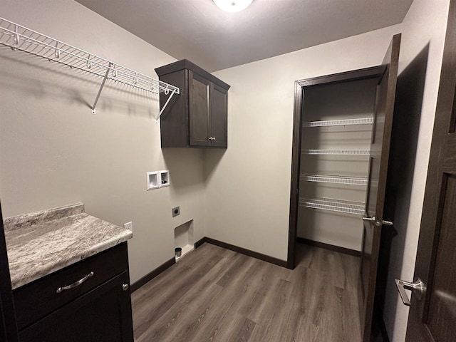 clothes washing area featuring cabinets, hookup for a washing machine, electric dryer hookup, and dark wood-type flooring