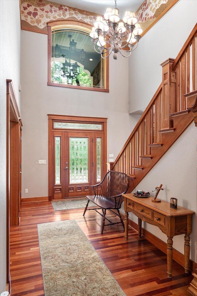 entryway with hardwood / wood-style flooring, a high ceiling, and an inviting chandelier