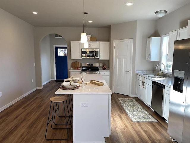 kitchen featuring sink, white cabinets, appliances with stainless steel finishes, and a center island