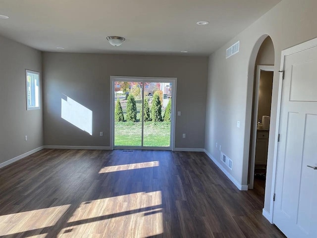 unfurnished room with dark wood-type flooring and plenty of natural light