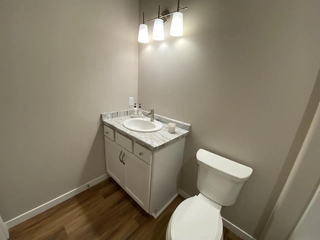 bathroom featuring hardwood / wood-style flooring, toilet, and vanity