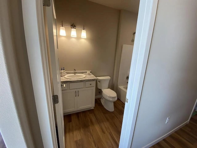 bathroom with wood-type flooring, toilet, and vanity