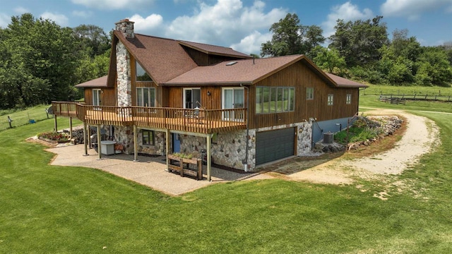 view of side of home with a garage, a lawn, a patio area, and a deck