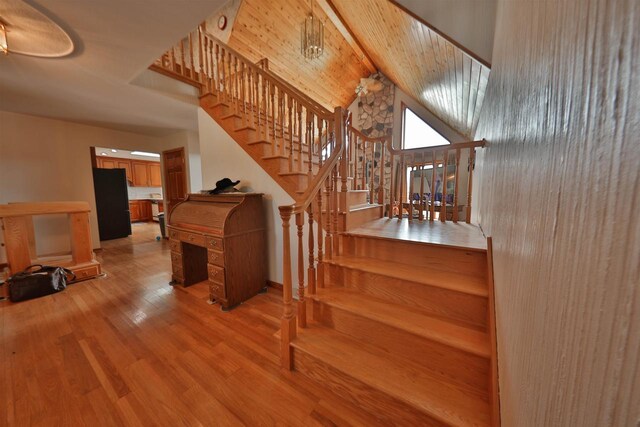 stairs with hardwood / wood-style flooring and vaulted ceiling with beams