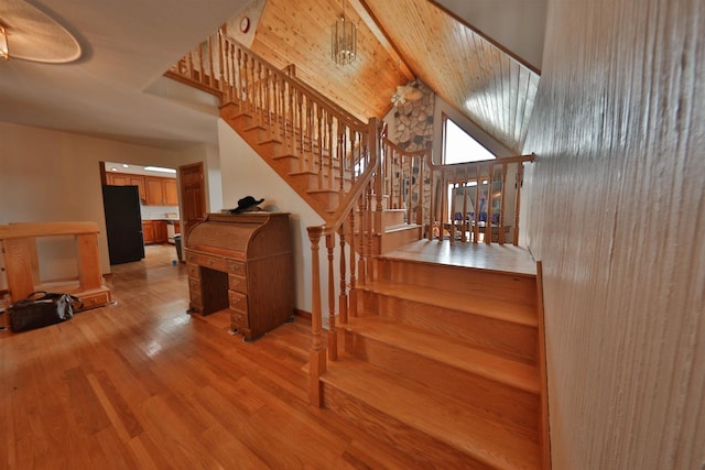 staircase featuring vaulted ceiling with beams, light wood-type flooring, and wood ceiling