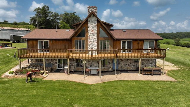 back of property with a wooden deck, a lawn, and a patio area