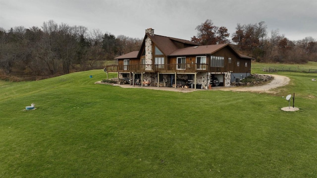 rear view of house with a deck and a yard