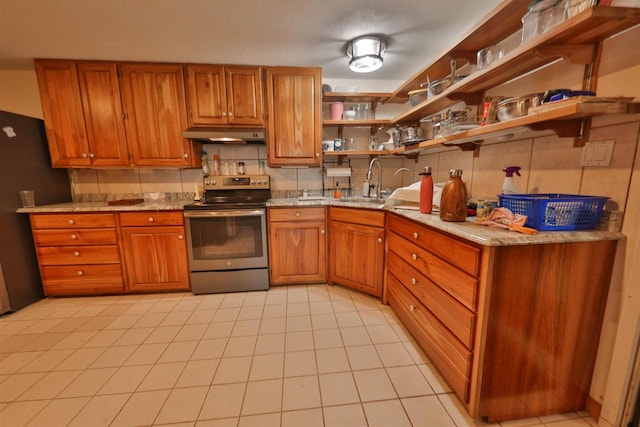 kitchen with light tile patterned flooring, stainless steel range with electric cooktop, and light stone countertops