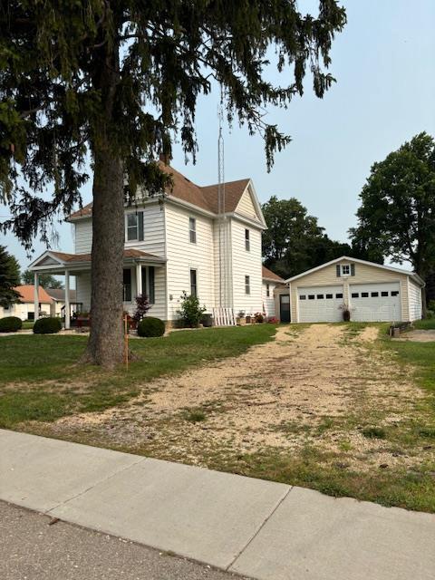 view of front of home featuring a front yard, a garage, and an outdoor structure