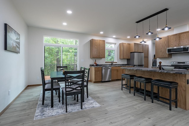 dining space featuring plenty of natural light, sink, and light hardwood / wood-style floors