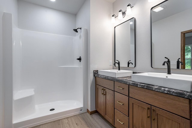 bathroom featuring vanity, wood-type flooring, and walk in shower